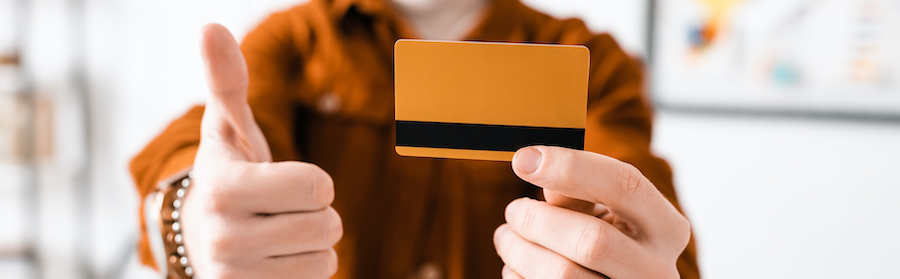 A man holding credit card with a thumb up indicating how to improve your credit score with a tradeline for sale